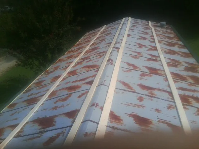 Rusted metal roof panels with new wood purlins before replacement — Storm Damage Roof Repair in Saluda by Roofing Brothers