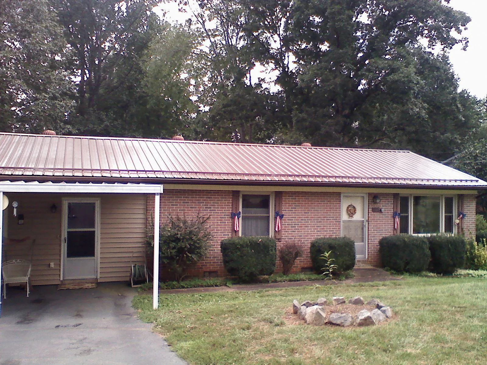 Bronze metal roof and carport on a brick ranch home — Roof Repair work by our crew in Saluda